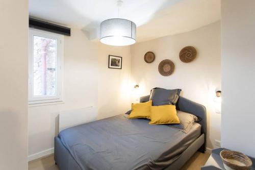 une chambre avec un lit avec des oreillers jaunes dessus dans l'établissement L16 Suite Malonat Vieux Nice 1 min Mer/ 2 chbres & AC, à Nice