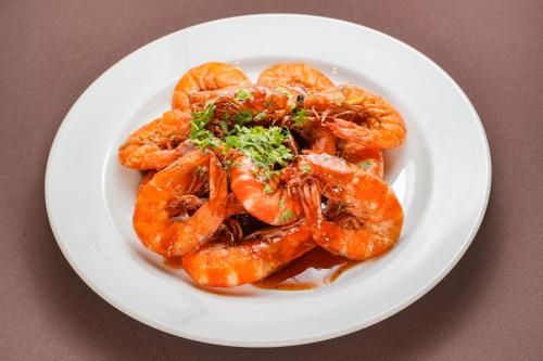 a white plate of shrimp on a table at มนต์เมืองเชียงใหม่ รีสอร์ต Monmuang Chiangmai Resort in Hang Dong