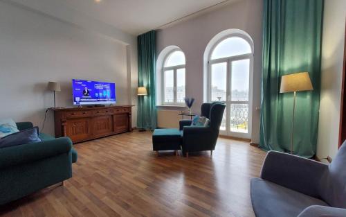 een woonkamer met groene gordijnen en een flatscreen-tv bij Apartamenty Sienkiewicza10 in Łomża