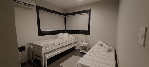 a small room with two beds and a window at Casa Cardales MINI PISCINA CLIMATIZADA in Sierra de la Ventana