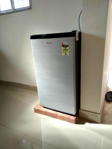 a white refrigerator sitting inside of a room at My Nest - Best Homestay for Peaceful Stay with Comfort in Bhuj