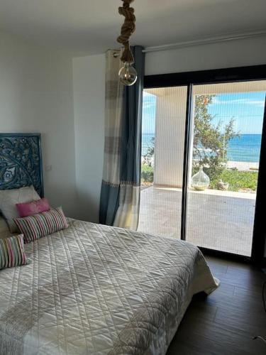 une chambre avec un lit avec vue sur l'océan dans l'établissement Maison les pieds dans l’eau, à Ghisonaccia