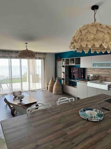 une cuisine et une salle à manger avec une grande table en bois dans l'établissement Maison les pieds dans l’eau, à Ghisonaccia