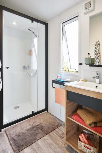 une salle de bain avec douche et lavabo dans l'établissement Camping Antioche D'Oléron, à La Brée-les-Bains