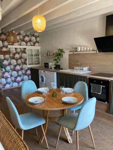 une cuisine avec une table en bois et des chaises bleues dans l'établissement La belle étoile, à Paimpont