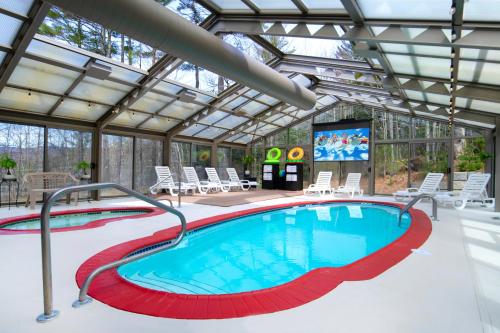 a swimming pool with a glass roof with chairs and a screen at Christmas Farm Inn and Spa in Jackson