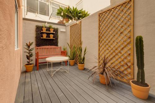 een patio met een bank, een tafel en planten bij La Papaya - Apartamento Alicante in Alicante