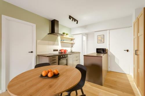 een keuken met een houten tafel met sinaasappels erop bij La Papaya - Apartamento Alicante in Alicante