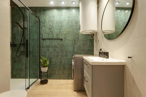 een badkamer met een douche, een wastafel en een spiegel bij La Papaya - Apartamento Alicante in Alicante
