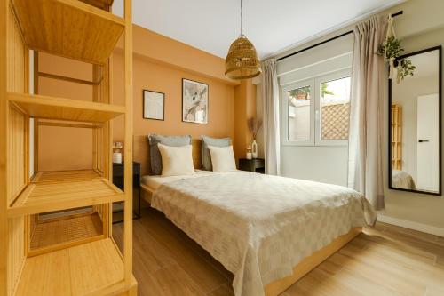 een slaapkamer met een bed en een groot raam bij La Papaya - Apartamento Alicante in Alicante