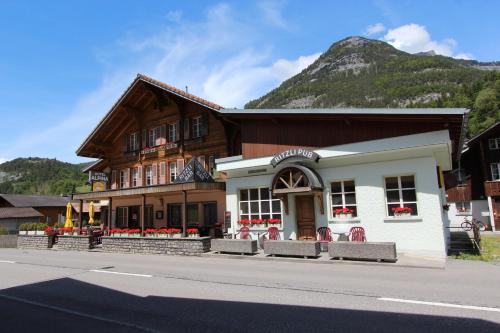 a building on the side of a street with a mountain at Hotel-Restaurant Alpina in Innertkirchen