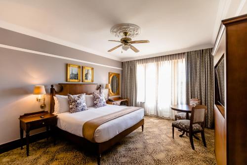 a hotel room with a bed and a desk and a window at Gold Reef City Hotel in Johannesburg