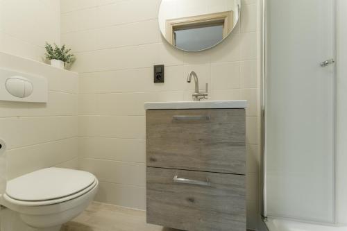 a bathroom with a toilet and a sink and a mirror at Vakantiewoning De zandberg in Pelt