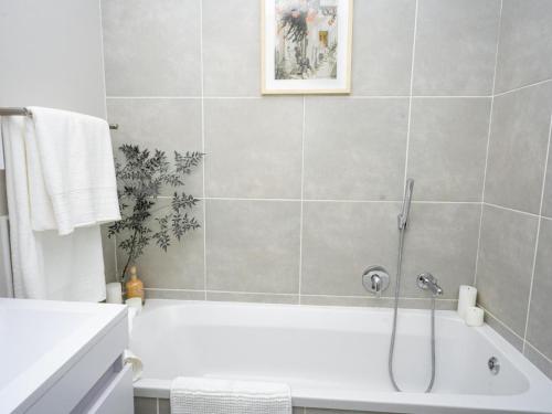 a bathroom with a white tub and a shower at Royal on 81 Ventura in Fourways