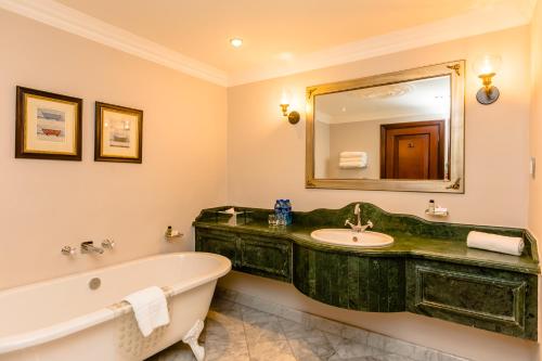a bathroom with a bath tub and a sink at Gold Reef City Hotel in Johannesburg