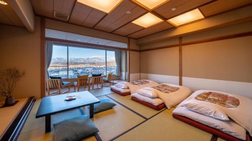 松本市にあるonsen hotel OMOTOのベッド2台とテーブルが備わる客室です。