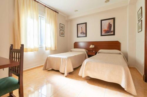- une chambre avec 2 lits et une fenêtre dans l'établissement Los Gallos, à Casabermeja