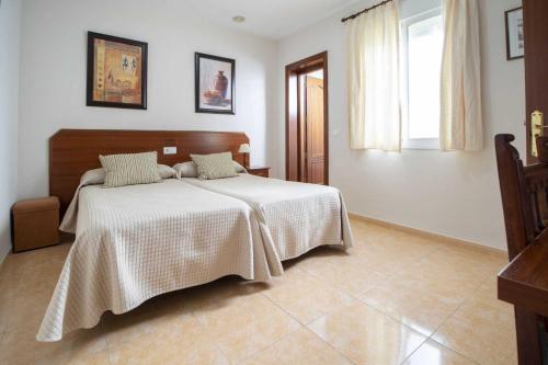 Schlafzimmer mit einem Bett mit weißer Bettwäsche und einem Fenster in der Unterkunft Los Gallos in Casabermeja