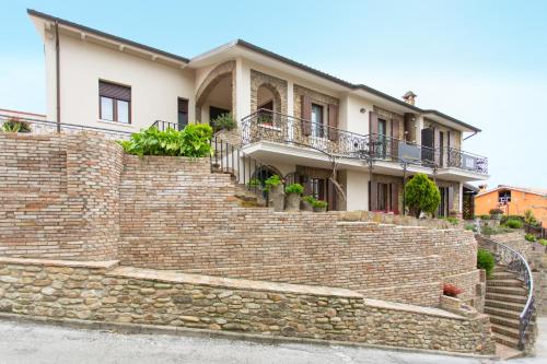 una casa con una pared de ladrillo y escaleras en Al Borgo Rooms, en Gradara