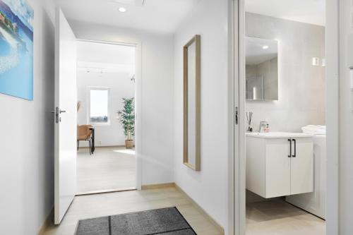 einen Flur mit weißen Wänden und einer Tür zum Bad in der Unterkunft Forenom Serviced Apartments Trondheim in Trondheim