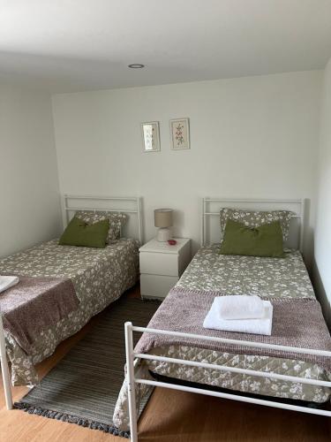 a bedroom with two beds with green pillows at Casa do Borges 