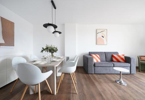 numa I Colmena Apartments في برشلونة: غرفة معيشة مع طاولة وكراسي وأريكة
