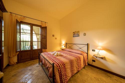 a bedroom with a bed in a room with a window at Agriturismo Due Ponti in Chianni