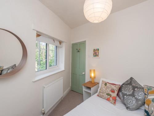 1 dormitorio con cama y puerta verde en Pass the Keys Wonky Cottage with amazing garden en Leeds