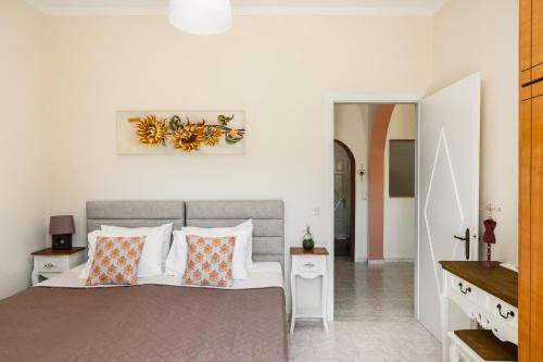 a bedroom with a bed with orange and white pillows at Ipsos & Barbati Panoramic Views by Konnect in Ipsos
