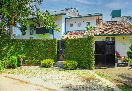 una valla cubierta de hiedra frente a una casa en Tranquill Villa La Dimora, en Gampaha