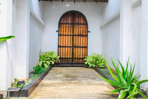 a front door of a white building with plants at Tranquill Villa La Dimora in Gampaha