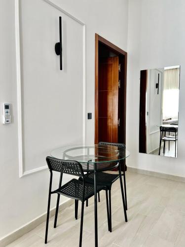 a glass table with two chairs and a mirror at MyCity in Rabat