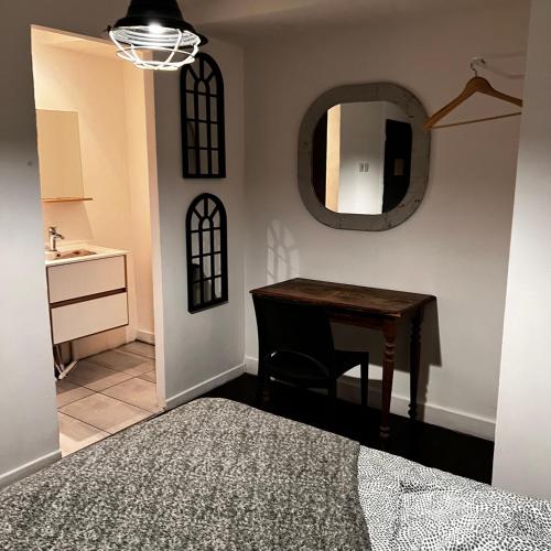 um quarto com uma mesa, um espelho e um lavatório em 5- Le Nid em Poitiers