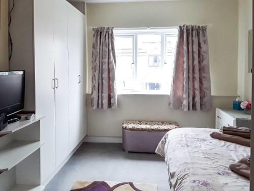 a bedroom with a bed and a window at Shirleys Cottage in Othery