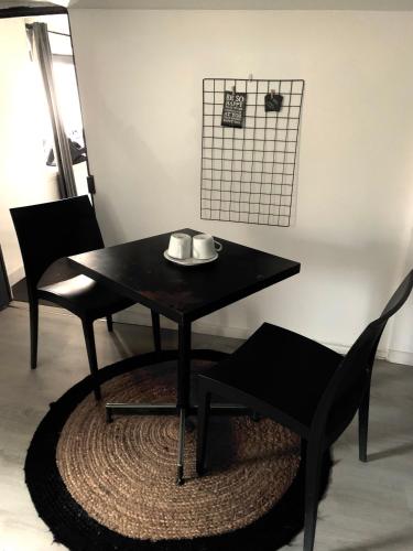 uma mesa preta com duas cadeiras e um prato sobre ela em 5- Le Nid em Poitiers
