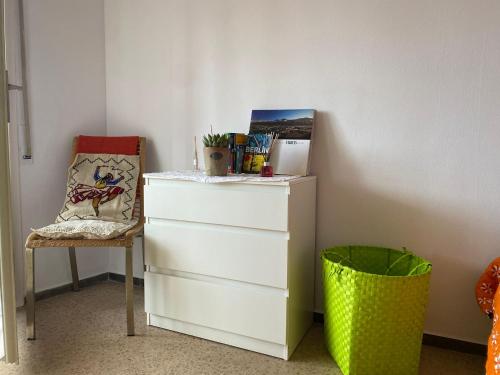 een wit dressoir en een stoel in een kamer bij Far from the Madding Crowd in Barcelona