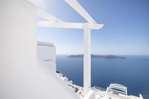 a view of the ocean from the side of a white building at Above Blue Suites in Imerovigli