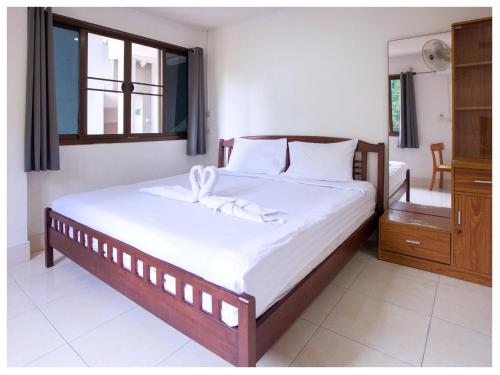 a bedroom with a bed with white sheets and a window at Namhasin House in Koh Tao