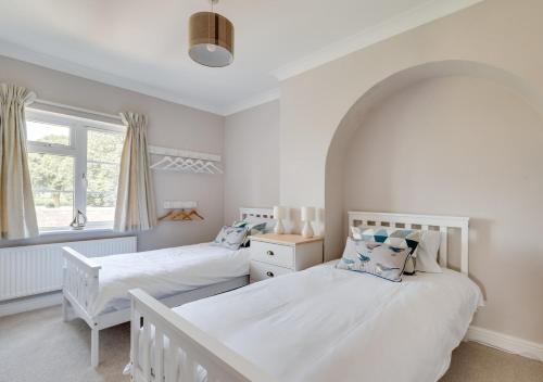 a bedroom with two beds and a window at 1 Lux Farm Cottages in Playford