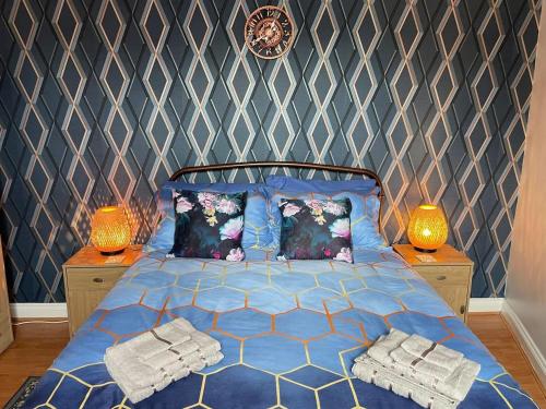 1 dormitorio con 1 cama azul y 2 lámparas en Impeccable 3-Bed Home Away From Home in Swindon, en Swindon