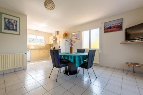uma cozinha e sala de jantar com mesa e cadeiras em Gîte L'Orée du Lac em Carcassonne
