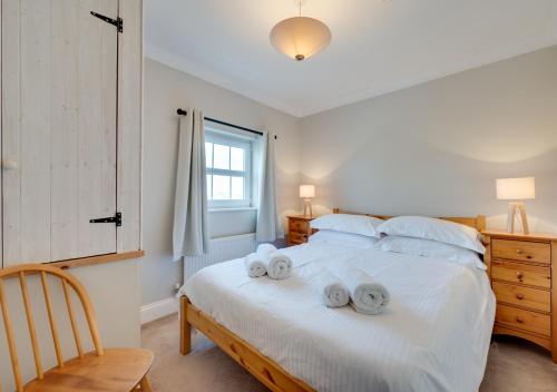 - une chambre avec un grand lit blanc et des serviettes dans l'établissement 2 Mill Farm, à Belchamp Otten