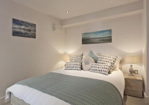 Schlafzimmer mit einem Bett mit blauen und weißen Kissen in der Unterkunft 1 White Point in Southwold