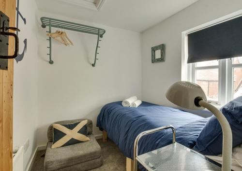 ein Schlafzimmer mit einem Bett, einem Stuhl und einem Fenster in der Unterkunft 3 Alde Lane in Aldeburgh