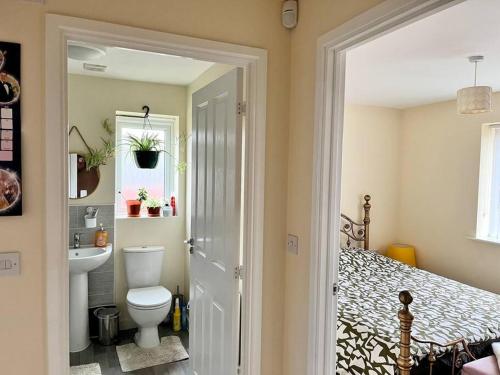 House with Breath of Fresh Air في Bloxwich: حمام به سرير ومغسلة ومرحاض