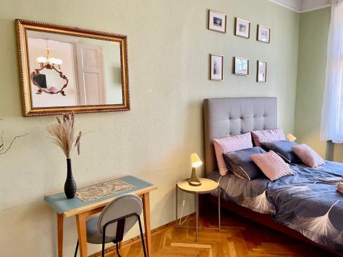 1 dormitorio con cama, espejo y mesa en Jolan Suite, en Budapest