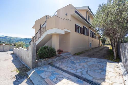a house with a stone path in front of it at Casa vacanza con vista panoramica in Viddalba