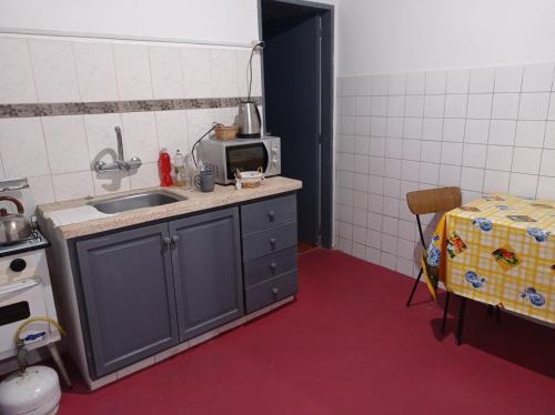 uma pequena cozinha com um lavatório e um micro-ondas em Tuc com em Durazno