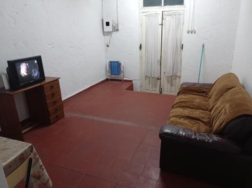 uma sala de estar com um sofá e uma televisão em Tuc com em Durazno