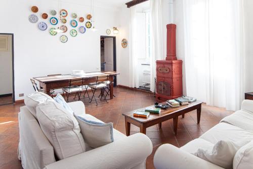 een woonkamer met witte meubels en een houtkachel bij Chiara House in Levanto
